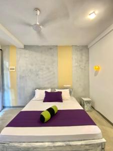 a bedroom with a large bed with purple and yellow stripes at Areca Bliss Villa in Koggala