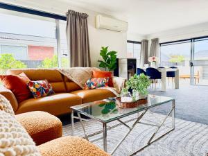 un salon avec un canapé et une table en verre dans l'établissement 6 Guests Family Home 7 Minutes to Airport, à Christchurch