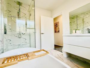 une salle de bain avec baignoire et douche en verre dans l'établissement 6 Guests Family Home 7 Minutes to Airport, à Christchurch 16 autres photos