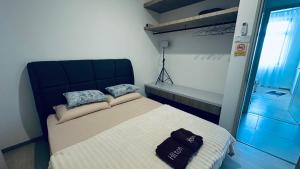 a bedroom with a bed with a black hat on it at NA Homestay Kota Samarahan in Kota Samarahan