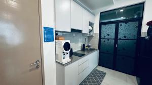 a small kitchen with a sink and a microwave at NA Homestay Kota Samarahan in Kota Samarahan