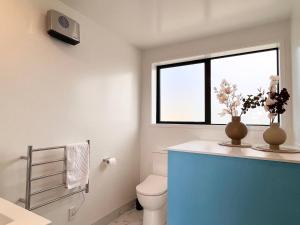 a bathroom with a toilet and a window at New 3 Storey luxe townhouse on quiet street in Christchurch +23 photos