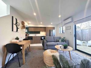 a living room with a couch and a table at Awesome new townhouse with KING Bed on Armagh in Christchurch