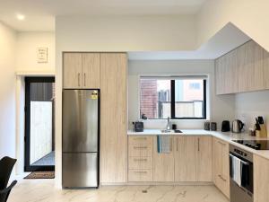 una cucina con frigorifero in acciaio inossidabile e finestra di Spacious luxe 3 story townhouse on Cashel street a Christchurch