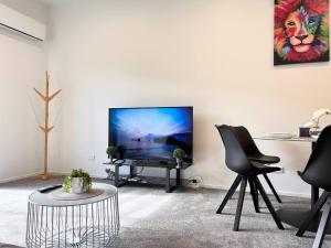 un soggiorno con una TV a schermo piatto su una parete di Spacious luxe 3 story townhouse on Cashel street a Christchurch