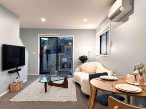 a living room with a couch and a table at Little Cutie on Worcester Quiet Stylish in Christchurch