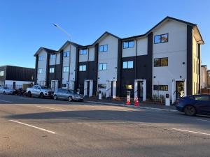 Un edificio con coches aparcados en un estacionamiento. en Premium Location 2beds2bath on Madras, en Christchurch