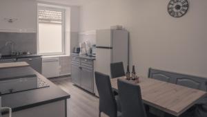 a kitchen with a table and a refrigerator at En famille au cœur des Vosges aux portes de l'Alsace, Vue château in Senones