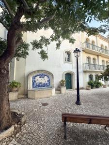 a bench in front of a building with a tree at Casa das Ancoras Historic Beach Guesthouse in Buarcos Portugal in Bicas +74 photos