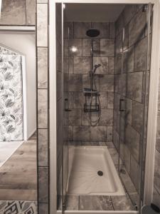 a bathroom with a shower with a tub at En famille au cœur des Vosges aux portes de l'Alsace, Vue château in Senones +30 photos