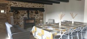 ein Esszimmer mit einem Tisch mit Stühlen und einem Kamin in der Unterkunft Cottage au cœur de l'Aubrac in Saint-Chély-dʼAubrac + 10 Fotos