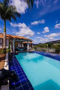 a pool with a gazebo and a palm tree at CASA POR do SOL in Tiradentes