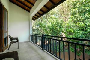 a balcony with a chair and a view of trees at Tropicara Resort in Sigiriya