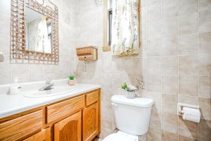 a bathroom with a toilet and a sink and a mirror at COZY 2 Bedroom in Montréal