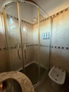 Un baño con ducha, lavabo e inodoro. en Takua del Lago, en Potrero de los Funes
