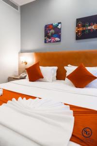 吉达Signature Guest Hotel فندق إمضاء النزيل الفندقية的配有2张床铺的酒店客房,提供白色和橙色枕头