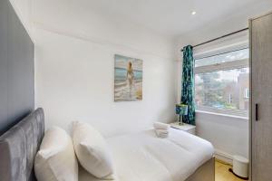 a white bedroom with a bed and a window at Modern 2 Bed Near Twickenham Stadium - 5 Min to Bus Stop in Hanworth