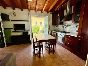 Una cocina con una mesa de madera y un comedor. en La Villetta, en Sulzano