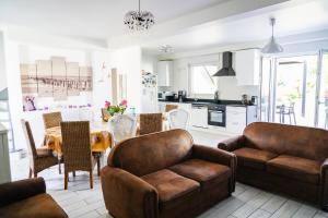 a living room with a couch and a table and a kitchen at Les Bleuets - Erdivines in Erdeven