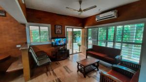 a living room with a couch and a tv at Cottage on Riverside in Irinjālakuda