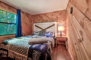 a bedroom with a bed in a wooden wall at Couples Getaway Hot Tub & Mountain View in Sevierville +58 photos