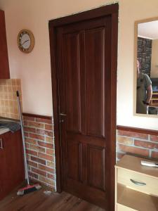 a wooden door in a room with a mirror at Gyulai Brill Apartman in Gyula