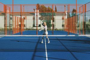 a woman is standing on a tennis court at Calipo in Vila Viçosa