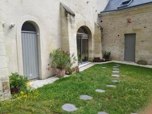 a courtyard of a house with a grass yard at Les Voies Blanches in Vouvray