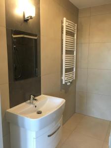 a bathroom with a white sink and a mirror at Panorama Gdynia Rooms in Gdynia