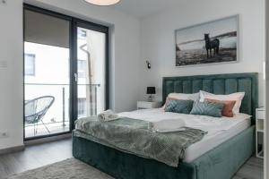 a bedroom with a large bed with a green headboard at Elegance Rezidence in Arad