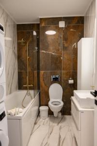 a bathroom with a toilet and a tub and a sink at Elegance Rezidence in Arad +19 photos