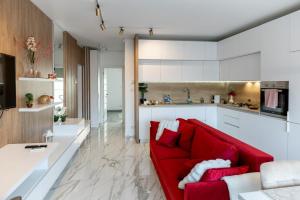 a living room with a red couch and a kitchen at Elegance Rezidence in Arad