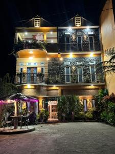 un bâtiment avec une table devant lui la nuit dans l'établissement Sapo Rumbia Homestay, à Berastagi