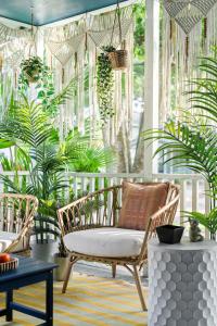 a room with two chairs and a table and plants at The Blue Bungalow - Peaceful, Porch, Hot Tub, Downtown in Orlando