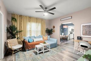 a living room with a blue couch and a table at The Blue Bungalow - Peaceful, Porch, Hot Tub, Downtown in Orlando