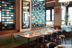 a row of tables in a restaurant with stained glass windows at Ace Hotel Brooklyn in Brooklyn