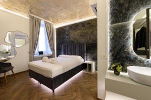 ein Schlafzimmer mit einem Bett und ein Badezimmer mit einem Waschbecken in der Unterkunft Antinous Suites in Rom