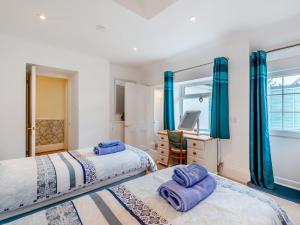 two beds in a room with blue curtains and a desk at 2 Bed in Bexhill-on-sea 95831 in Bexhill