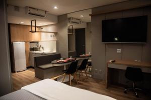 una stanza con due sedie e una cucina con tavolo di Apartamentos sofisticados no coração do Batel a Curitiba