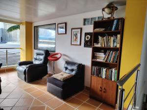 a living room with two chairs and a book shelf at Hotel Posada La Porra in Concordia