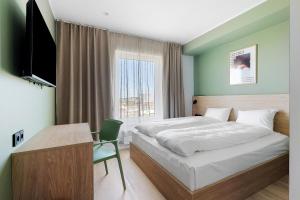 a bedroom with a bed and a desk and a television at Aiden by Best Western Odense in Odense +71 photos
