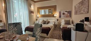 a bedroom with two beds and a table and a mirror at La Stanza Di Giulietta in Verona