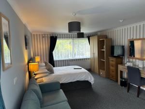 a hotel room with a bed and a couch at Rothay House in Ambleside