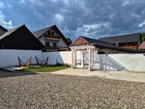 a white building with a white wall and a fence at Casa Stefania Breb in Breb