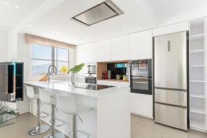 a kitchen with white cabinets and a large white island at Profithome - Tabaiba Tenerife in Santa Cruz de Tenerife
