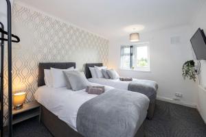 two beds in a room with white walls at Bright and Modern 2 Bed Home w Garden in Liverpool in Liverpool