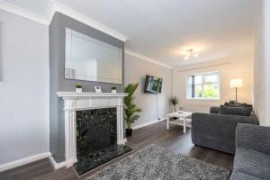 a living room with a fireplace and a couch at Bright and Modern 2 Bed Home w Garden in Liverpool in Liverpool +16 photos