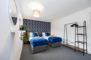 a bedroom with two beds with blue sheets and a shelf at Bright and Modern 2 Bed Home w Garden in Liverpool in Liverpool
