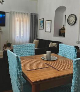 a dining room table with blue chairs and a couch at Old soul, Sea views in Dhërmi