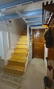 a staircase in a room with a wooden door at Old soul, Sea views in Dhërmi